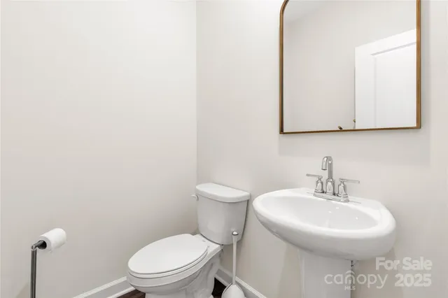 a bathroom with a toilet a sink and mirror