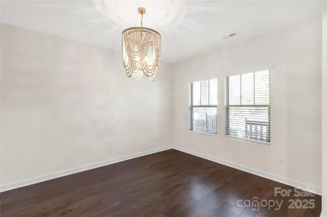 an empty room with wooden floor and window