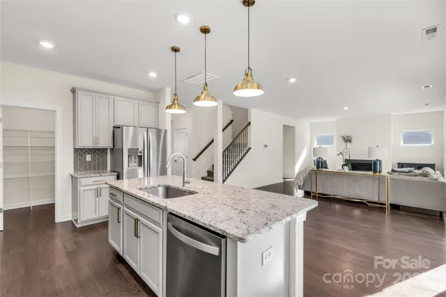 a kitchen with stainless steel appliances kitchen island granite countertop a sink a counter space and cabinets