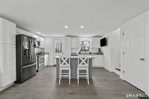 a kitchen with stainless steel appliances a refrigerator and wooden floor