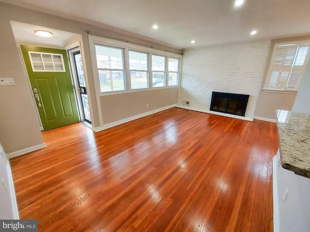 an empty room with wooden floor and a fireplace