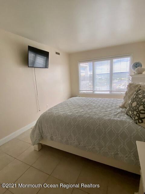 438 Highway 35, Unit 5305 Mantoloking, NJ 08738 - Photo 25 of 40 a bedroom with a bed and a flat screen tv