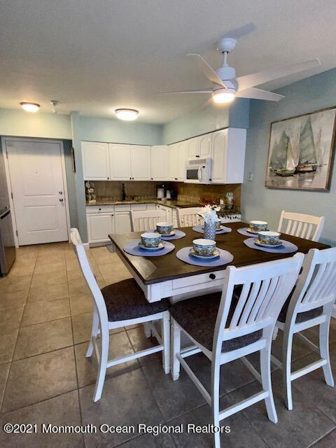 438 Highway 35, Unit 5305 Mantoloking, NJ 08738 - Photo 5 of 40 a dining room with a wooden table and chairs