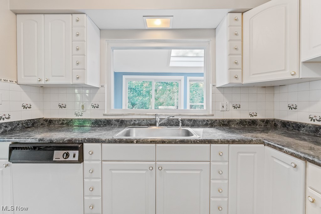 9049 Prospect Road Strongsville, OH 44149 - Photo 10 of 50 Kitchen featuring white cabinets, backsplash, white dishwasher, and sink