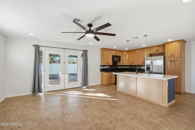 an empty room with ceiling fan and window