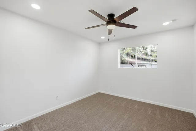 an empty room with closet and a ceiling fan
