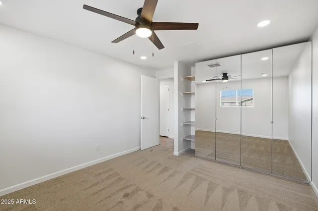 a view of a white house with a big yard and potted plants