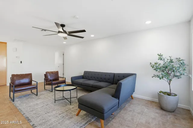 a living room with furniture and a wooden floor