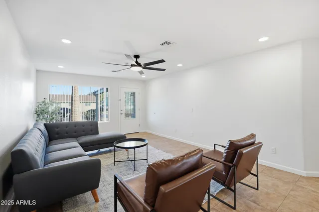 a view of a livingroom with a fireplace and a chandelier fan