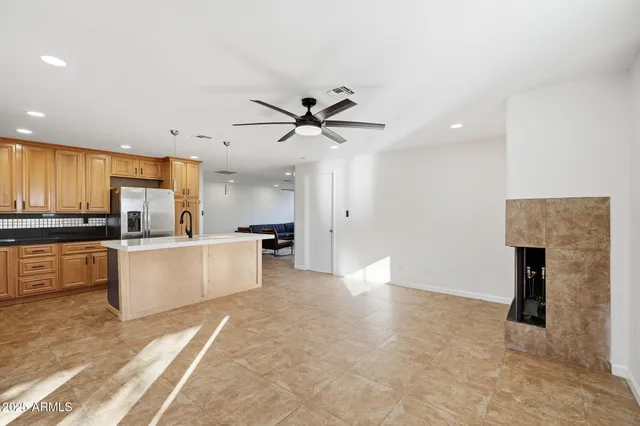 a view of an empty room with a ceiling fan and window