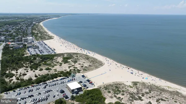 a kitchen with stainless steel appliances granite countertop a refrigerator a sink a stove a dining table and chairs with wooden floor