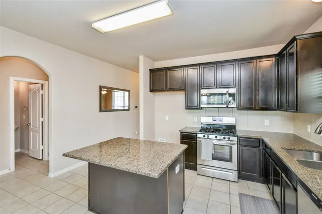 a kitchen with granite countertop stainless steel appliances cabinets a sink and a counter space