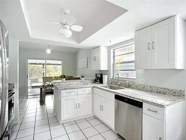 a bathroom with a granite countertop sink vanity mirror and toilet
