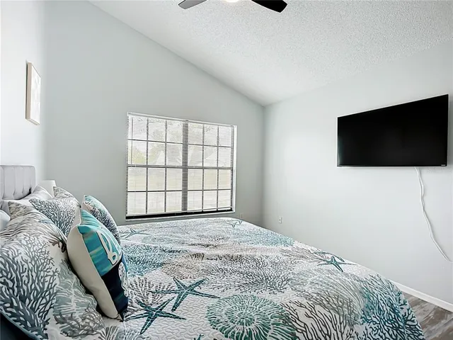 a view of a white house with a big yard and potted plants