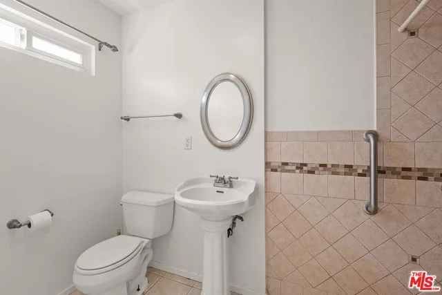 a bathroom with a sink a toilet and a mirror