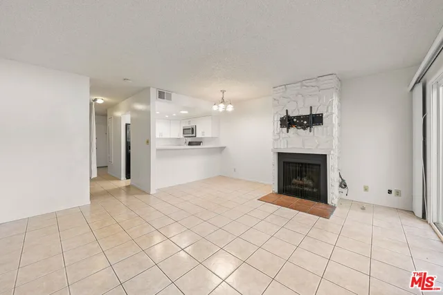 a large white kitchen with cabinets and a refrigerator