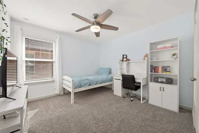 a bedroom with a large bed and a ceiling fan