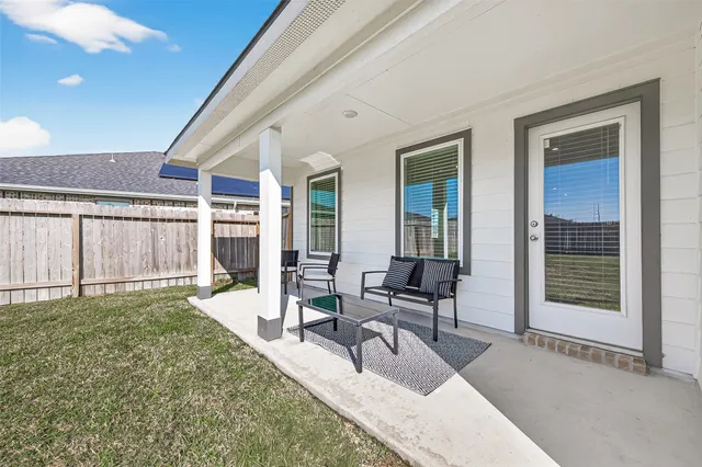 a living room with a couch and chairs next to a window