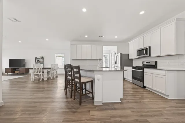 a kitchen with stainless steel appliances granite countertop a stove top oven a sink dishwasher and a refrigerator