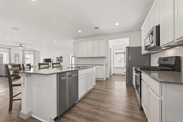 a kitchen with stainless steel appliances a stove a microwave and cabinets