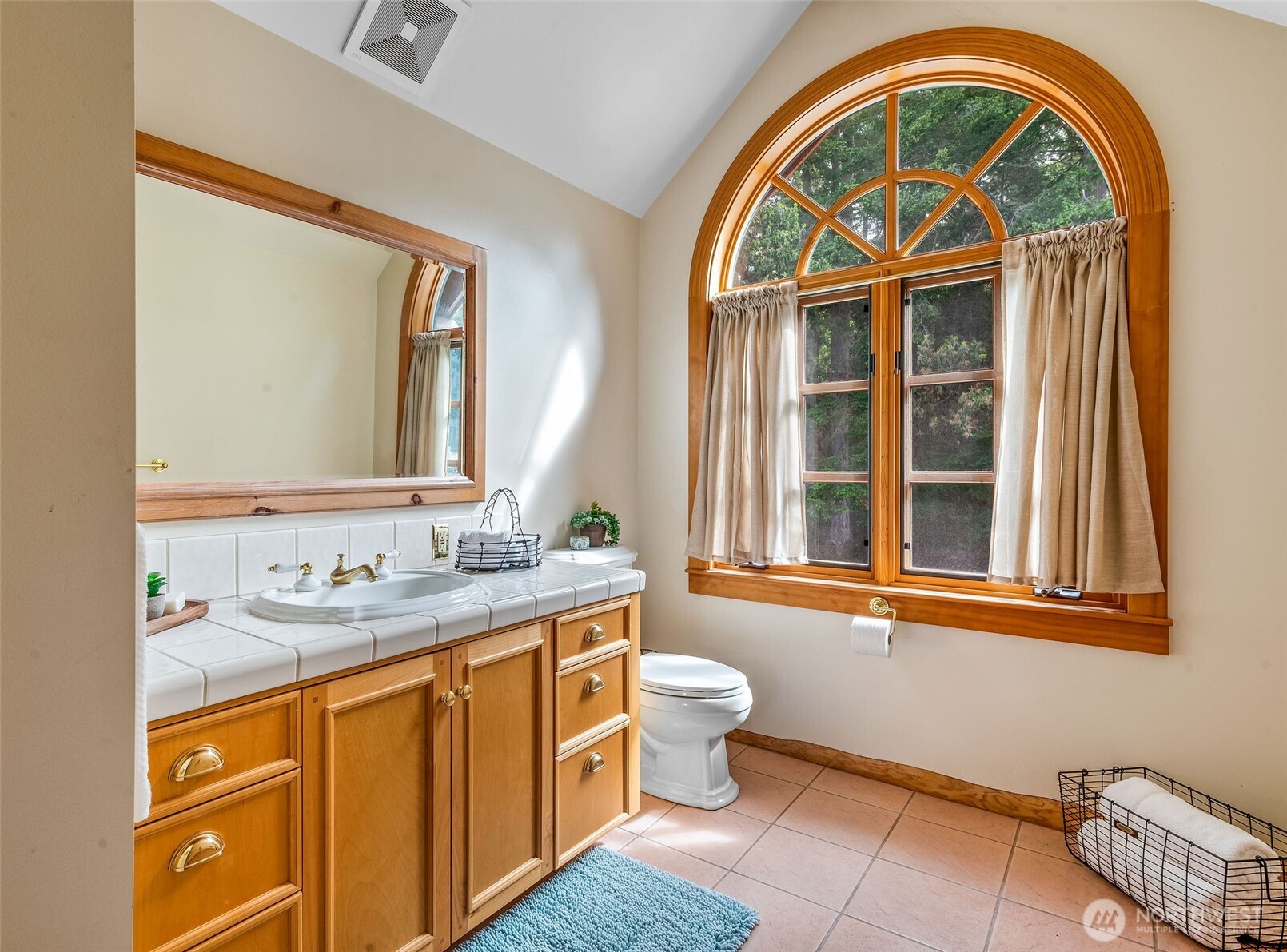 53 Combs Place Port Townsend, WA 98368 - Photo 36 of 40 a bathroom with a granite countertop toilet a mirror and a window