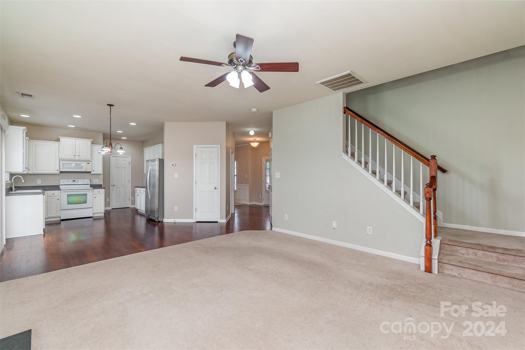 3320 Burnage Hall Road Harrisburg, NC 28075 - Photo 4 of 21 a view of a livingroom with a ceiling fan and kitchen view