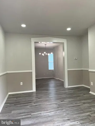 an empty room with wooden floor and entrance