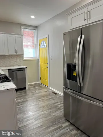a kitchen with stainless steel appliances a refrigerator and a stove top oven