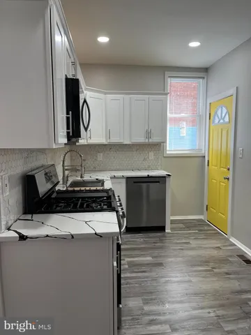 a kitchen with stainless steel appliances granite countertop a stove a sink and a refrigerator