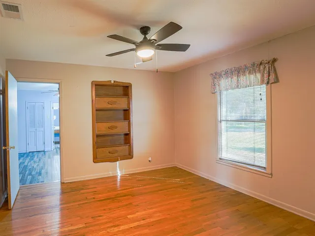 an empty room with windows and closet