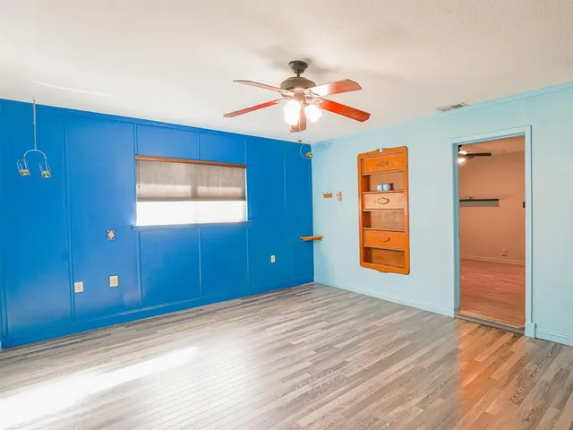 a view of empty room with window and wooden floor