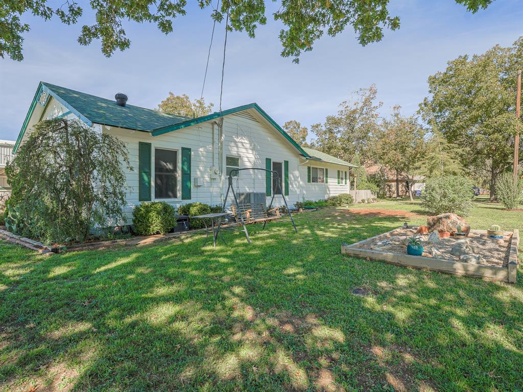 438 South Street Krum, TX 76249 - Photo 3 of 22 Side of property with a yard and large mature trees!