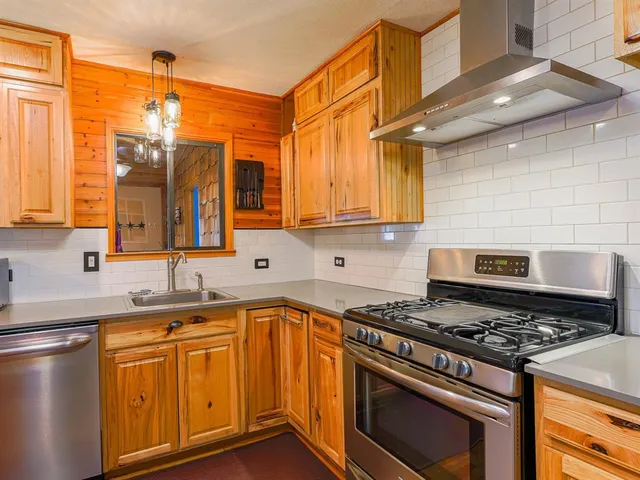a kitchen with stainless steel appliances a stove a sink and a microwave
