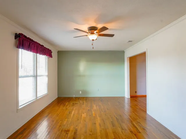 wooden floor in an empty room with a window