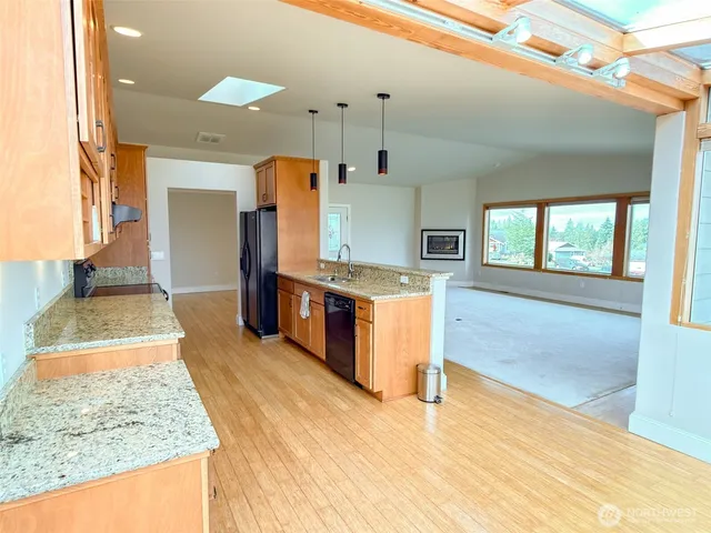 a large kitchen with stainless steel appliances granite countertop a sink and a stove