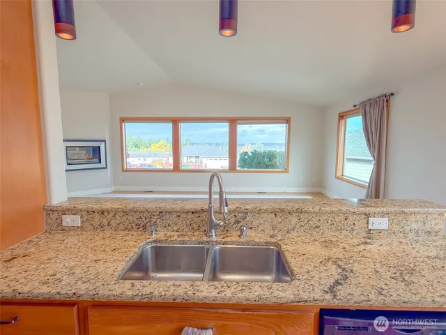 a kitchen with granite countertop sink and window