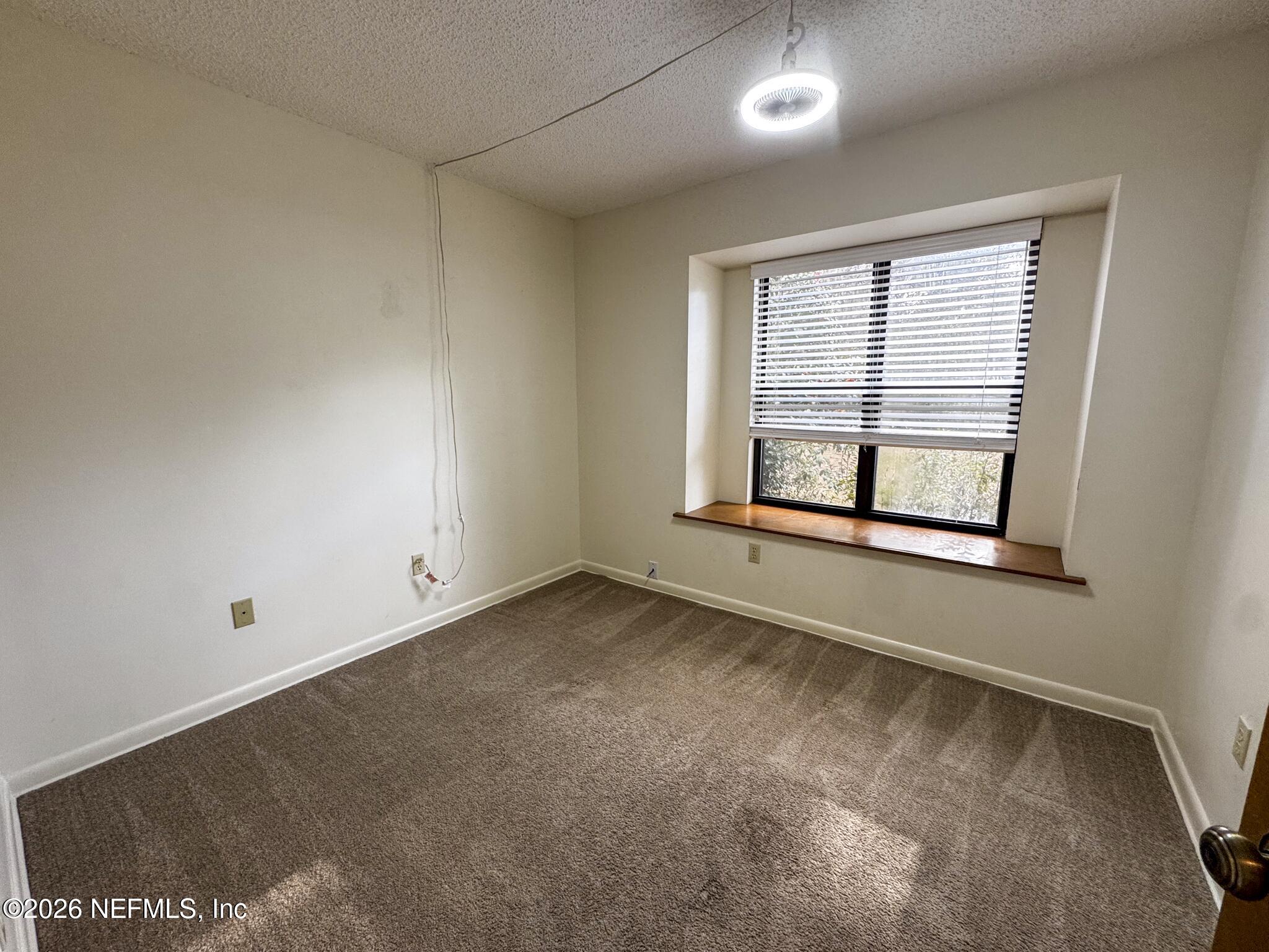 114 Mandarin Lake Road Melrose, FL 32666 - Photo 14 of 26 an empty room with a fireplace and windows