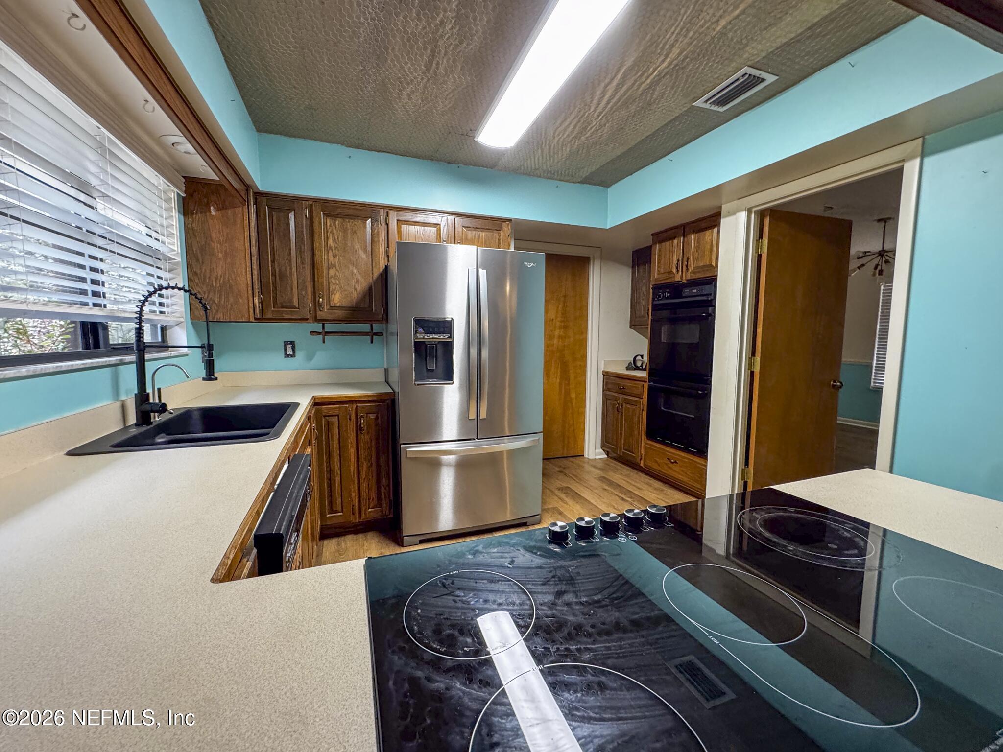 114 Mandarin Lake Road Melrose, FL 32666 - Photo 5 of 26 a kitchen with a refrigerator sink and wooden floor