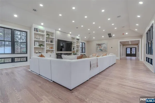 a living room with stainless steel appliances furniture large window and wooden floor