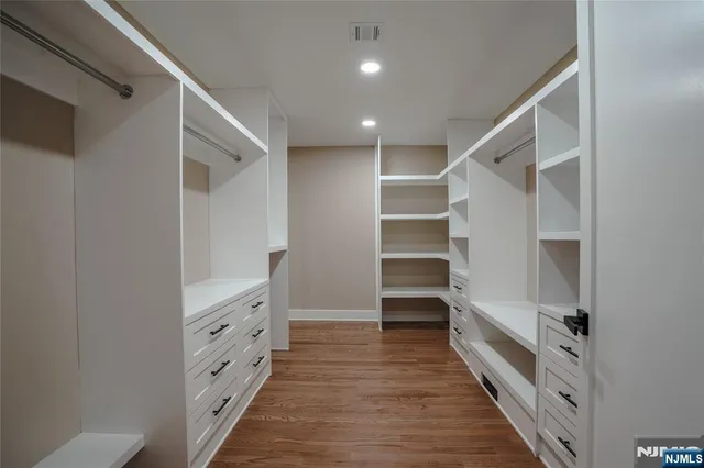 a view of walk in closet with empty racks