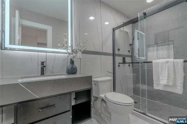 a bathroom with a sink toilet a mirror and shower