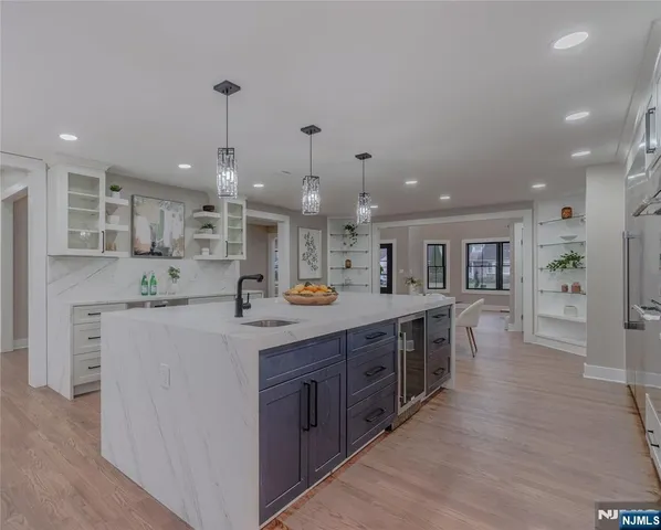 a large kitchen with kitchen island a sink a stove and a refrigerator