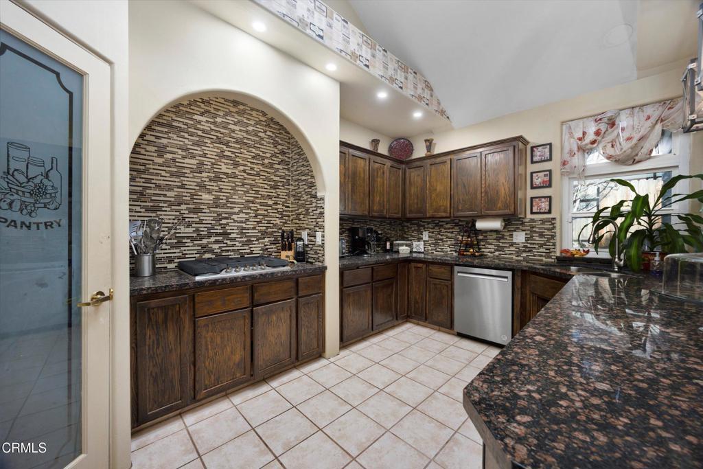 5705 Valley Street Bakersfield, CA 93306 - Photo 24 of 53 a kitchen with stainless steel appliances kitchen island granite countertop a stove a sink and a microwave