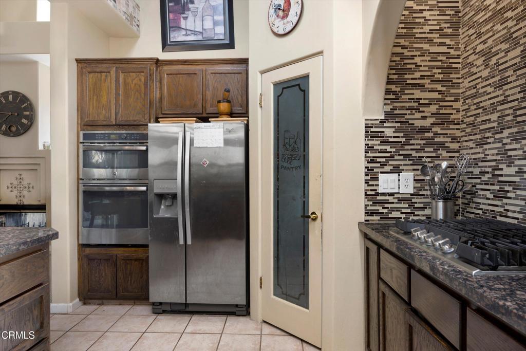 5705 Valley Street Bakersfield, CA 93306 - Photo 27 of 53 a kitchen with granite countertop a refrigerator and a stove