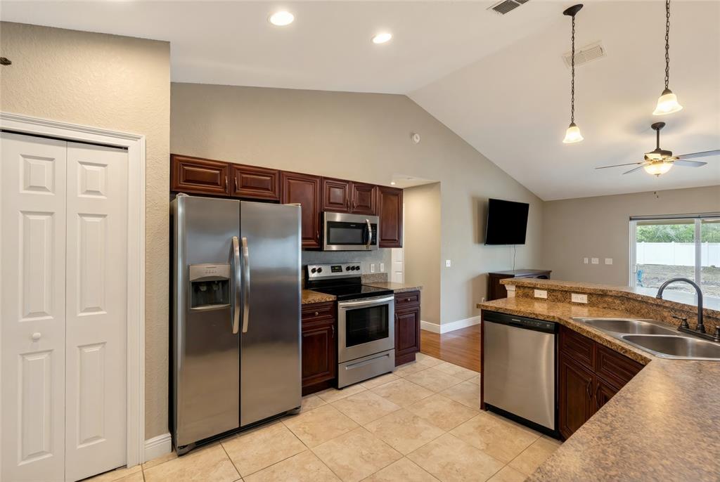 3001 Southwest 173rd Street Road Ocala, FL 34473 - Photo 11 of 28 a kitchen with stainless steel appliances granite countertop a sink a stove and a refrigerator