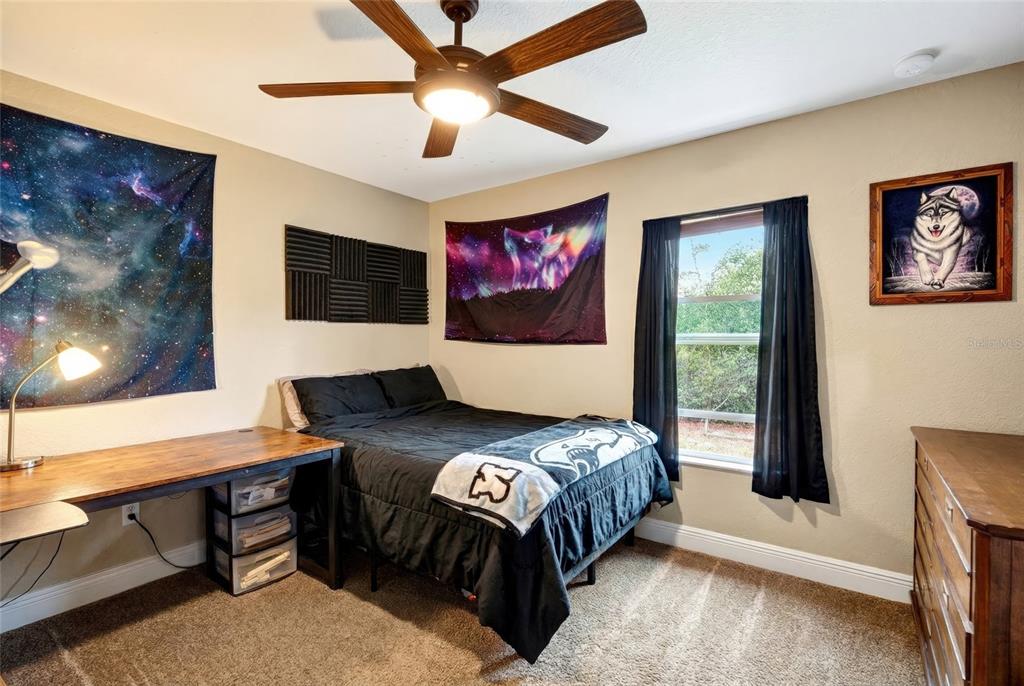 3001 Southwest 173rd Street Road Ocala, FL 34473 - Photo 17 of 28 a bedroom with a bed and a flat screen tv