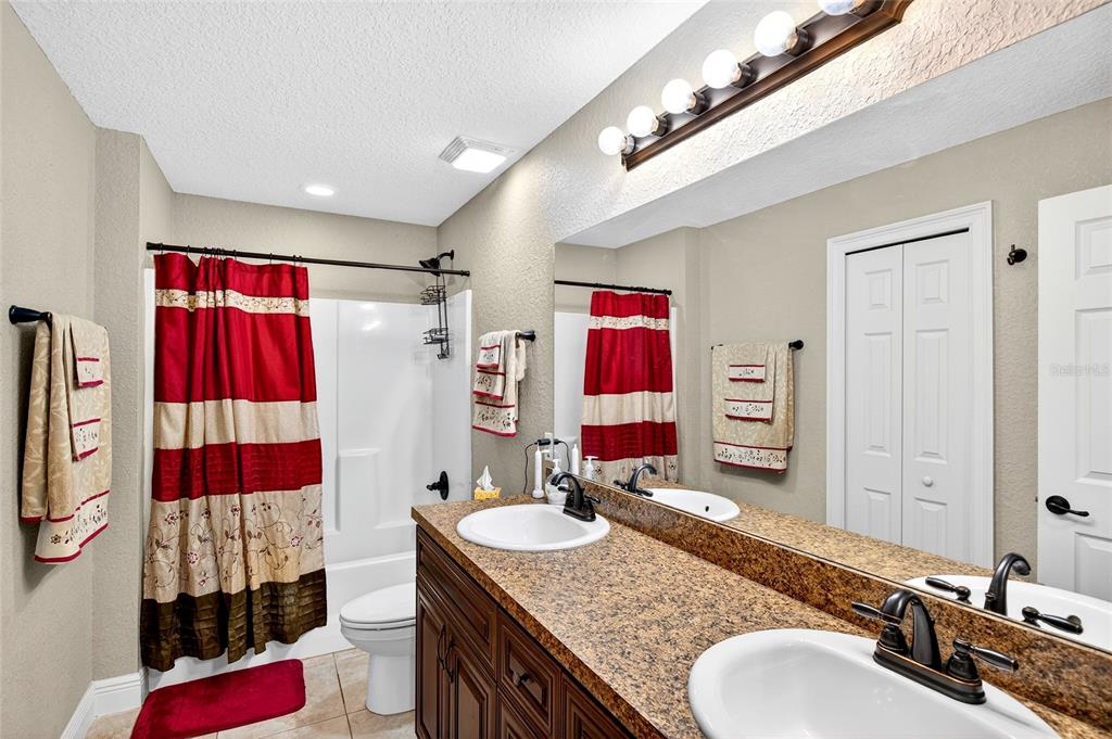 3001 Southwest 173rd Street Road Ocala, FL 34473 - Photo 18 of 28 a bathroom with a granite countertop double vanity sink and shower