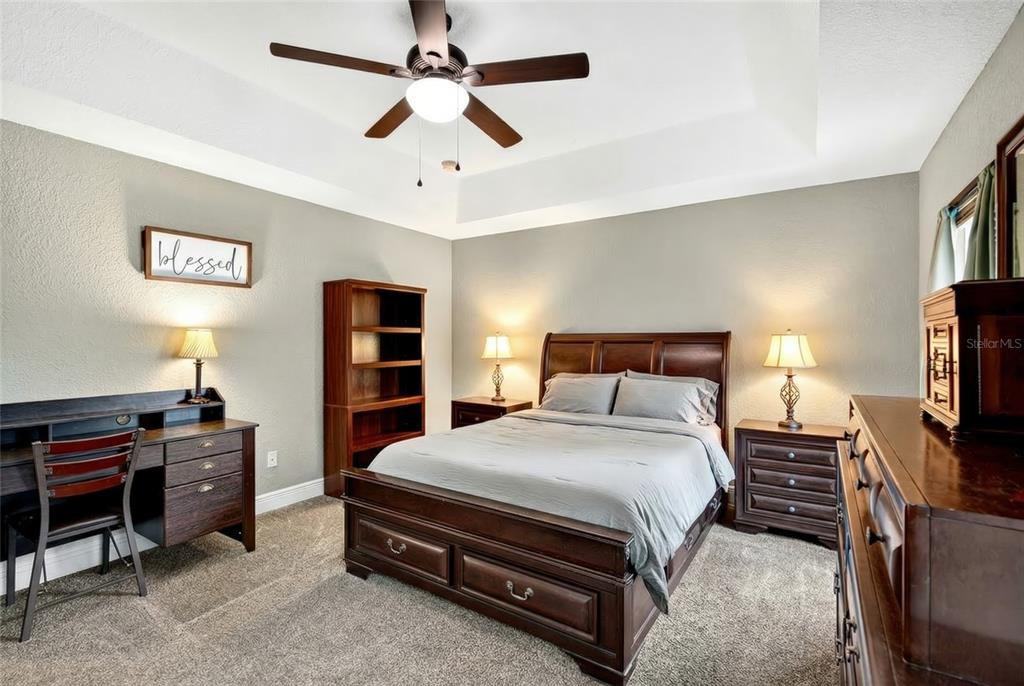 3001 Southwest 173rd Street Road Ocala, FL 34473 - Photo 21 of 28 a spacious bedroom with a bed and a flat screen tv