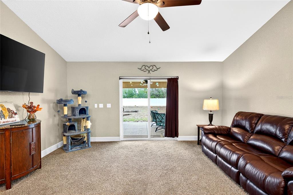 3001 Southwest 173rd Street Road Ocala, FL 34473 - Photo 24 of 28 a living room with furniture and a flat screen tv
