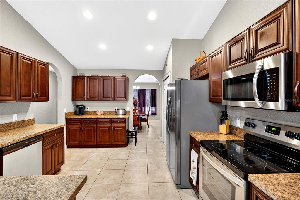 3001 Southwest 173rd Street Road Ocala, FL 34473 - Photo 10 of 28 a kitchen with stainless steel appliances granite countertop a stove and a sink